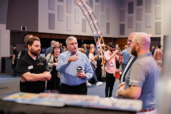 Men talking at a technology event hosted by High Point Networks