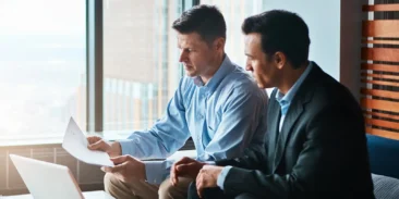 cyber-insurance | High Point Networks Two businessmen reviewing cyber insurance paperwork in office together